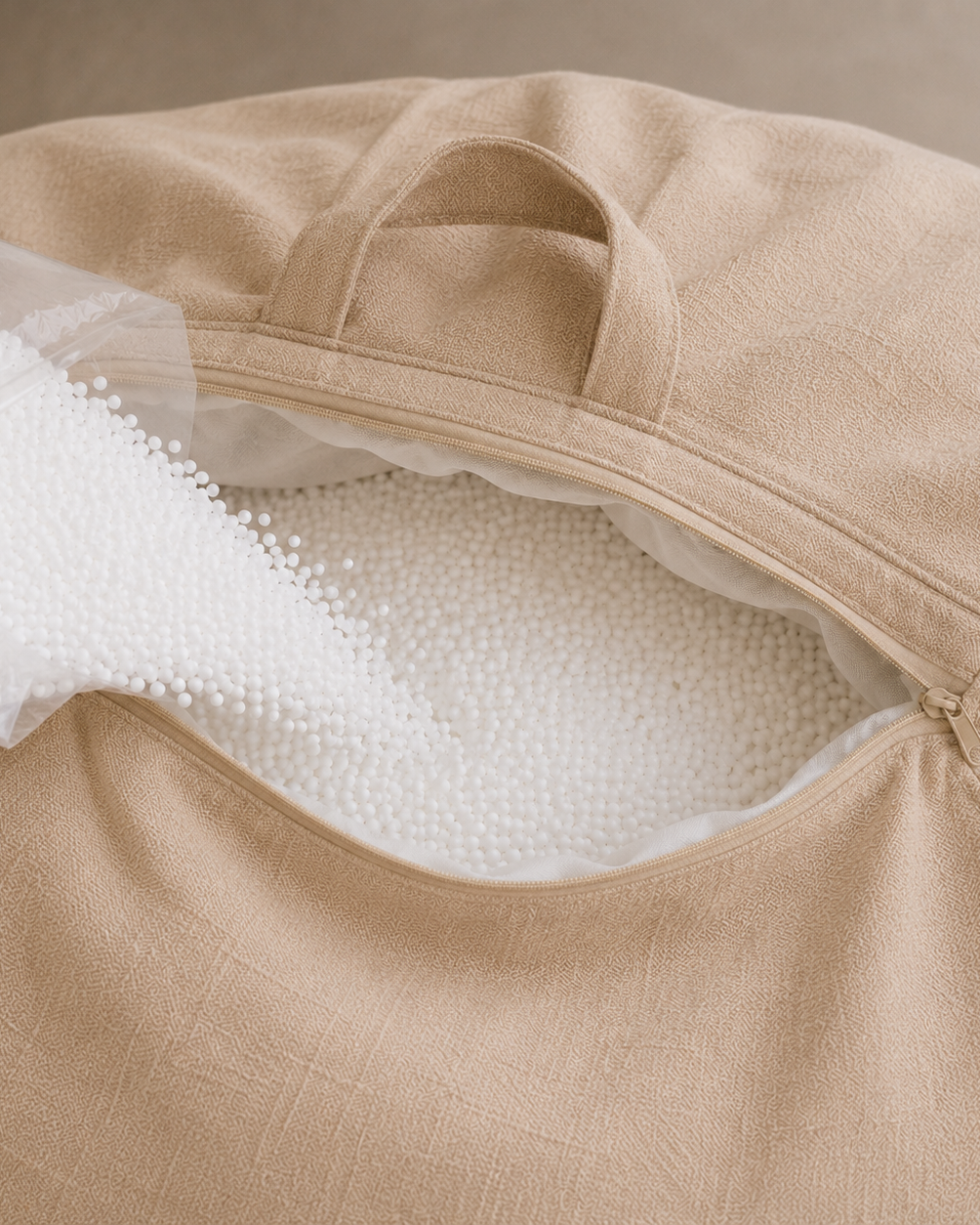 Ouverture du pouf beige Mowana avec billes de remplissage ajustables pour personnaliser le confort Image