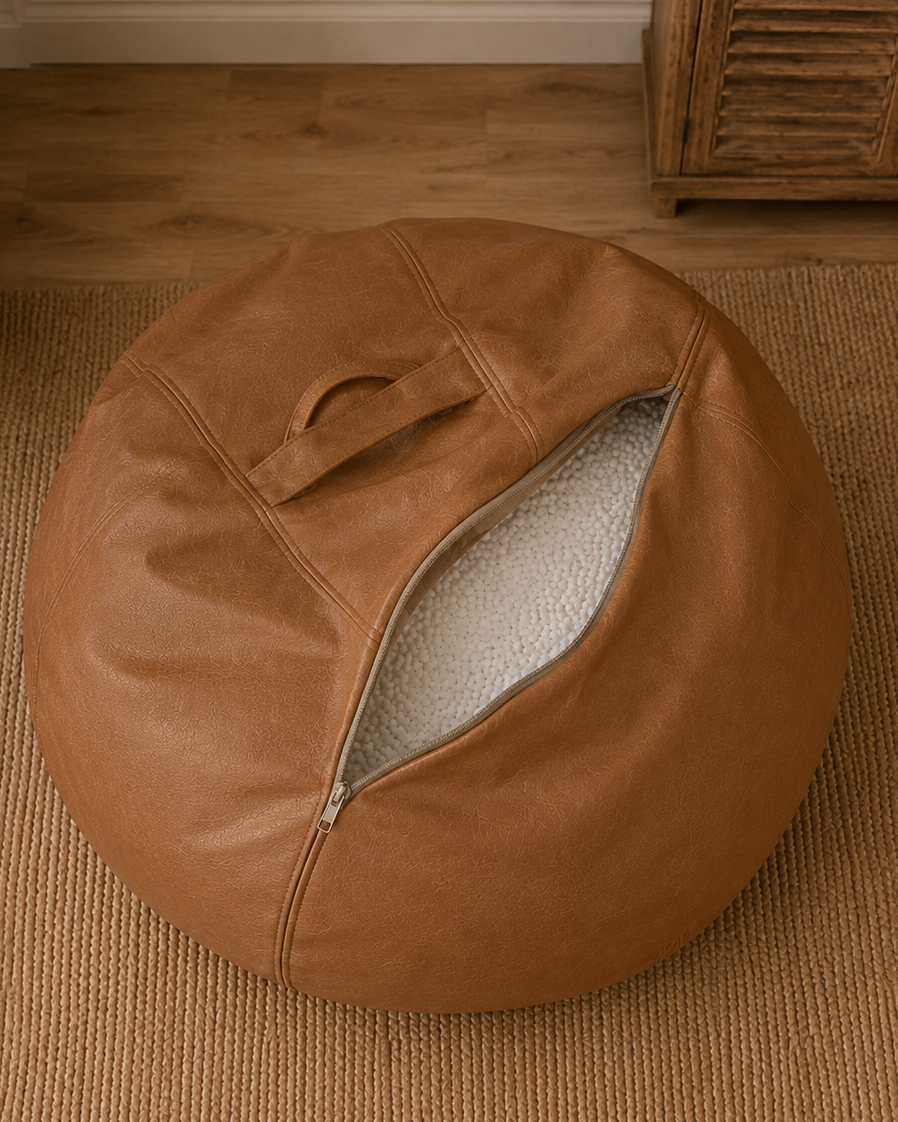 Ouverture zippée du pouf en simili cuir cognac Mowana montrant le remplissage en billes de polystyrène