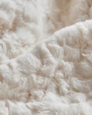 Zoom sur la matière fausse fourrure écrue du pouf Alba Mowana avec texture douce et chaleureuse Image