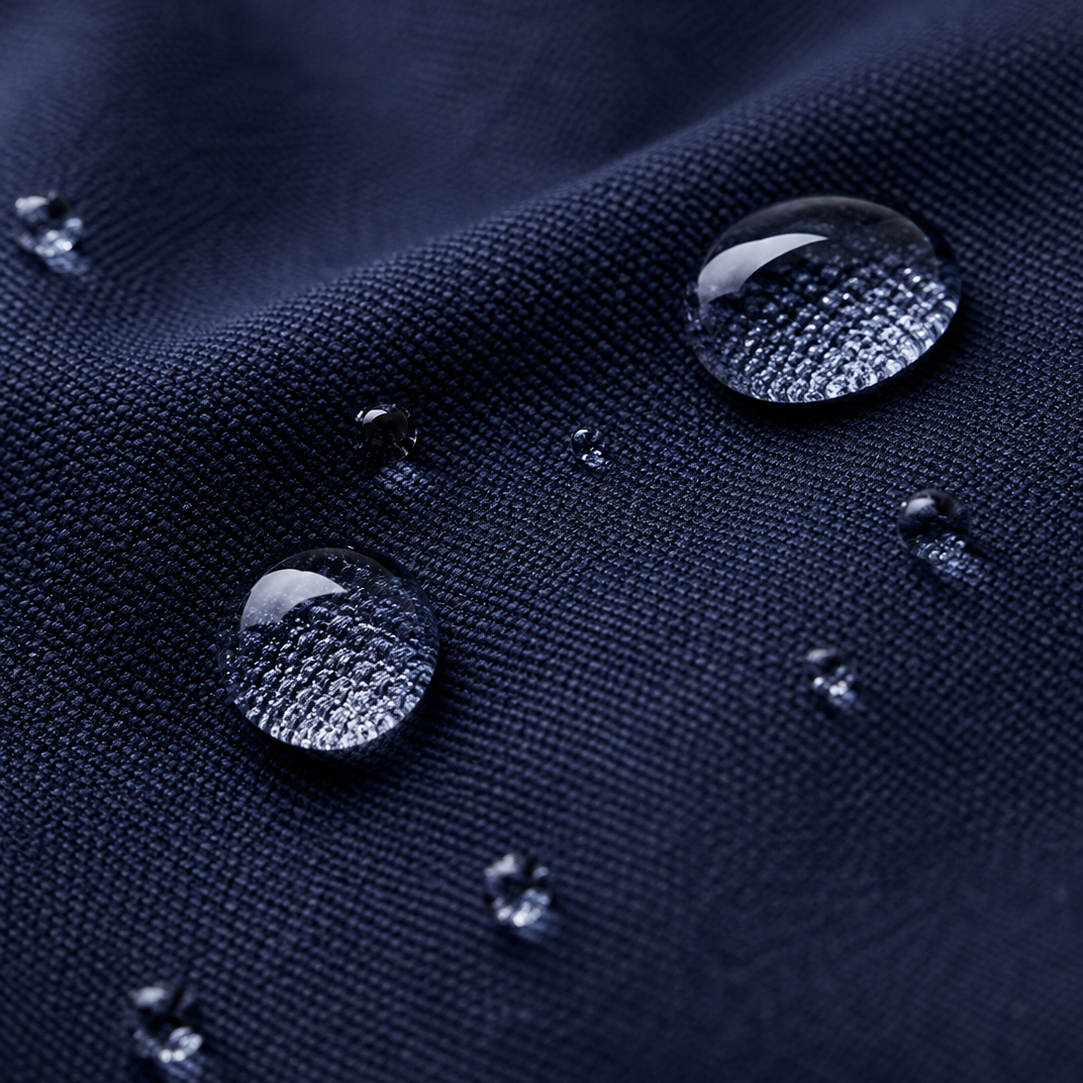 Zoom sur la matière imperméable bleu marine du pouf extérieur Mowana avec gouttes d’eau en surface