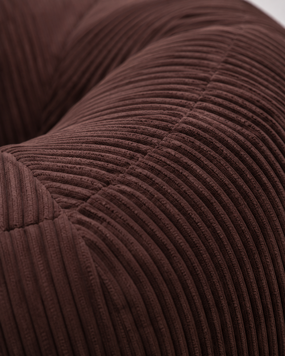 Zoom sur la texture côtelée marron moka du pouf Mowana avec tissu doux et finitions premium